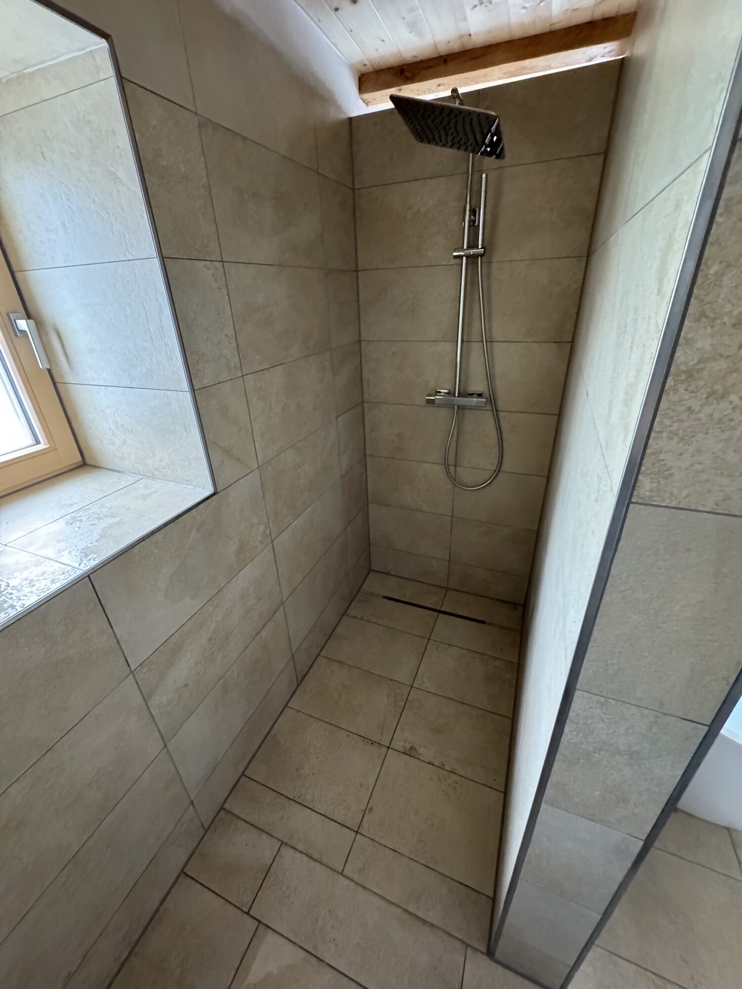 Bodengleiche Dusche mit Regenbrause und Glasabtrennung im neuen Bad