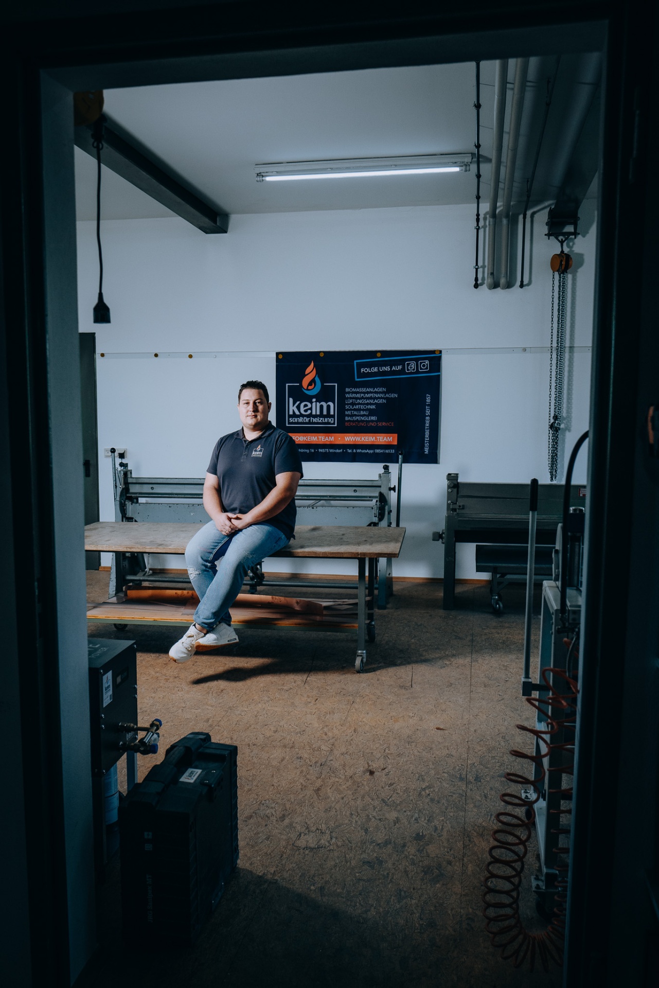 Christoph Keim durch die Werkstatttür gesehen, Bauspenglerei-Equipment im Vordergrund.