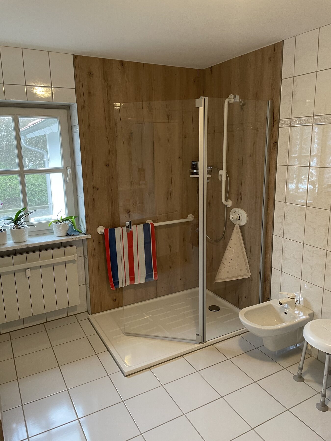 Neue Dusche mit fugenloser Rückwand in Holzoptik und Glasabtrennung im Bad in Schöllnach