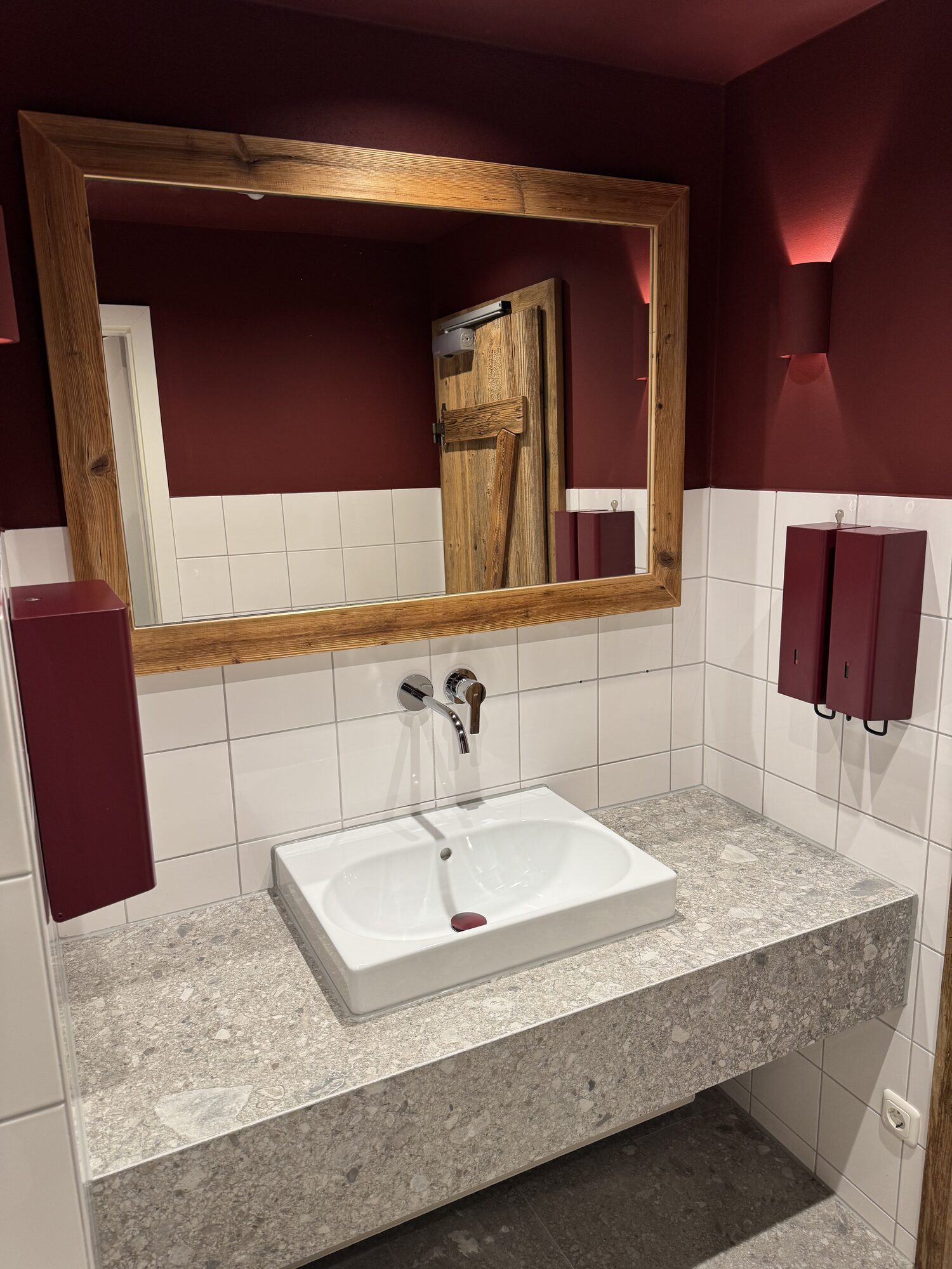Blick in den neu gestalteten WC-Bereich mit Altholz, Stein und RAL-Farbwelt