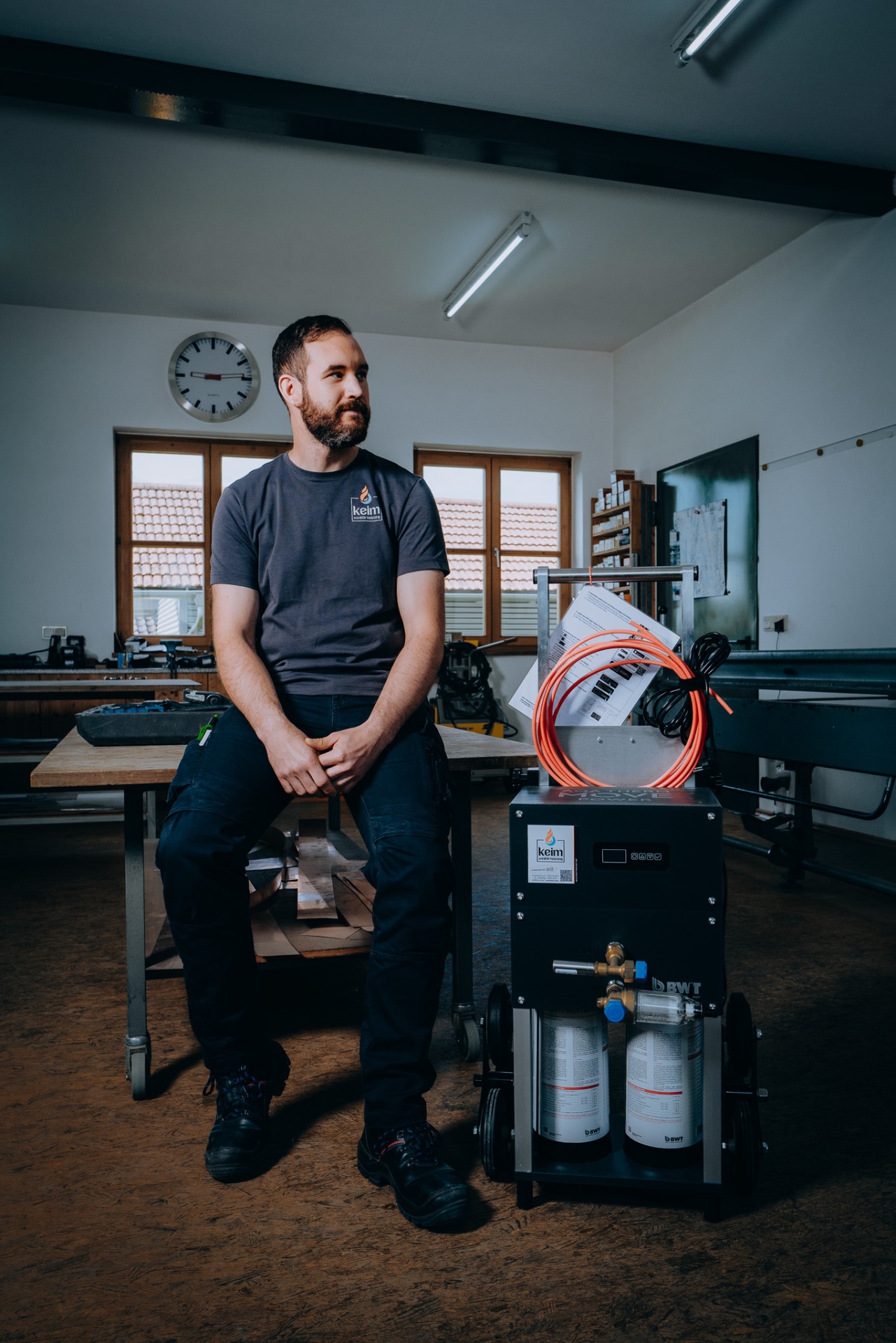 Christoph Keim blickt zur Seite, neben sich die BWT AQA therm MOVE Power Anlage.