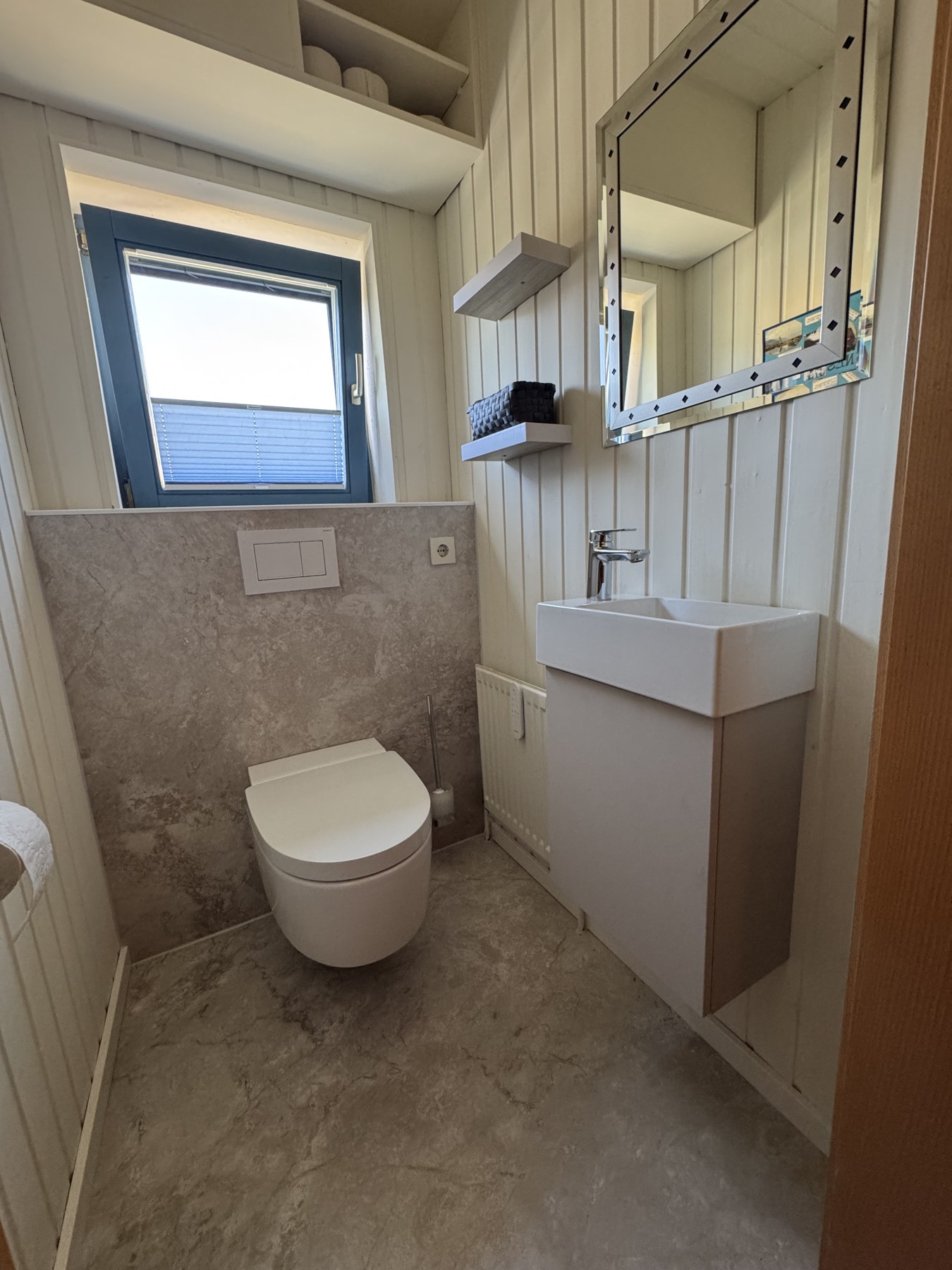 Blick auf Waschtisch mit Unterschrank, Spiegel und Ablagen im neuen Gäste-WC