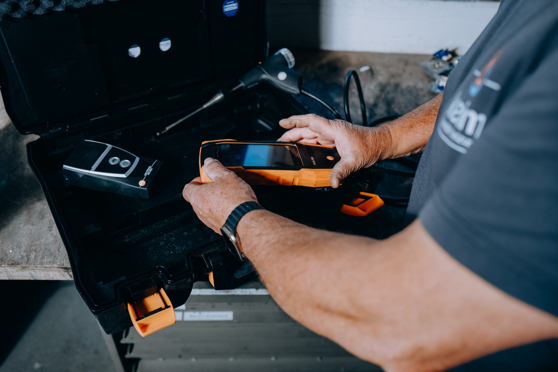 Ein keim-Mitarbeiter nimmt das Testo-Abgasanalysegerät aus dem Servicekoffer.