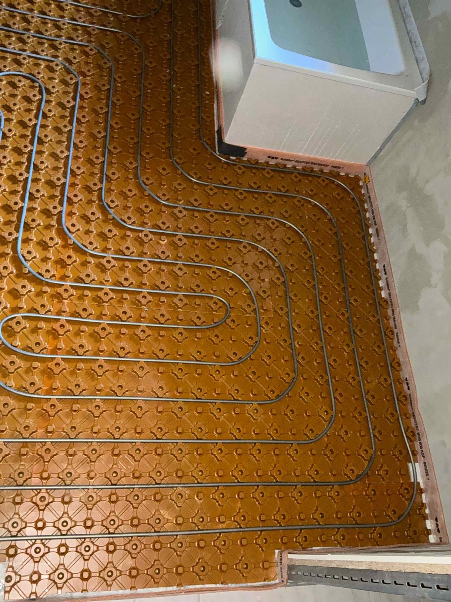 Detail der neu verlegten Fußbodenheizungsrohre auf Noppenplatten