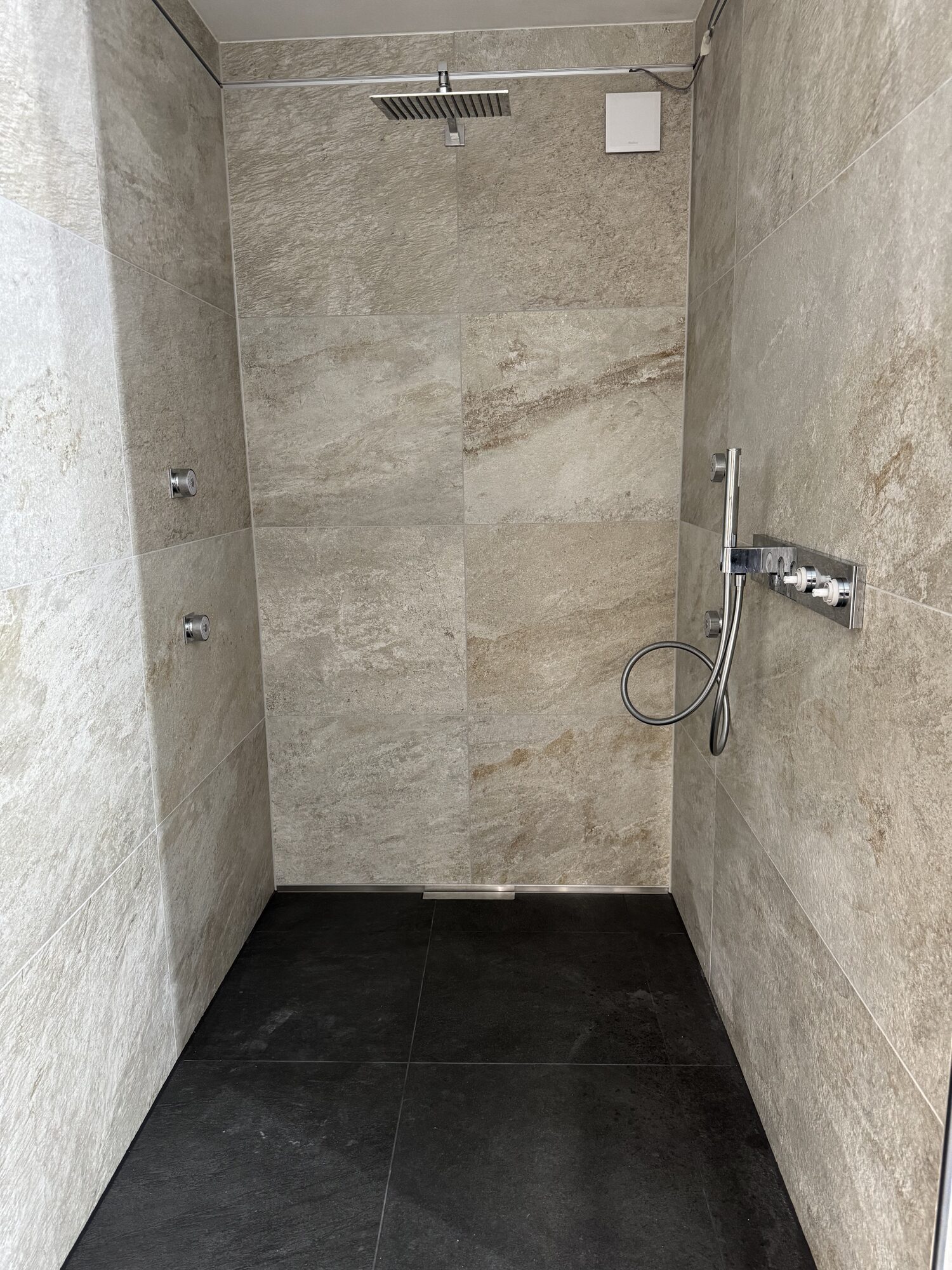 Große bodengleiche Dusche mit Regenbrause und Unterputz-Armatur im Neubau